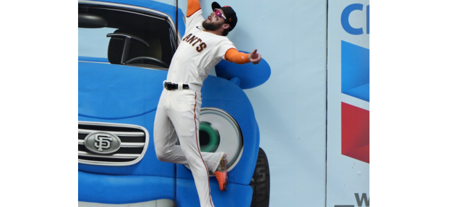 San Francisco Giants outfielder Luis González leaps up right at the wall to make a spectular catch of Chicago Cub Christopher Morel’s fly ball.